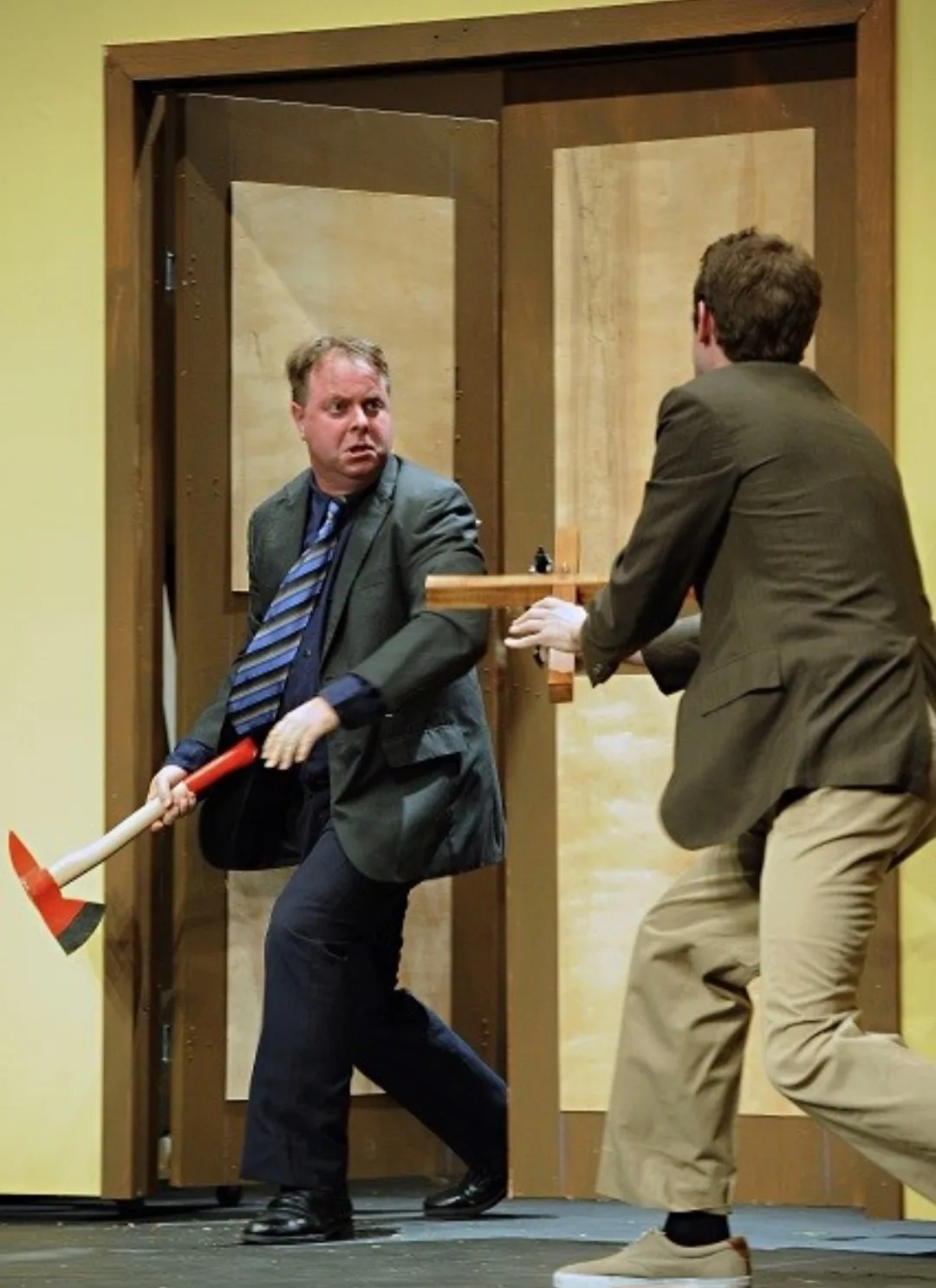 Mark Novak holding a prop axe during a comedy stage production