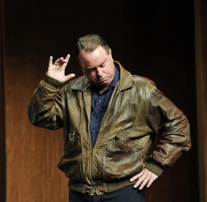 Mark Novak performing on stage in a leather jacket