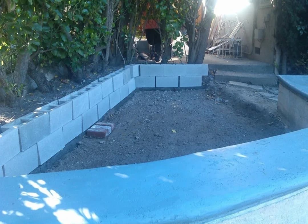 Masonry retaining wall laid out around a landscaped area